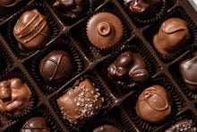 Load image into Gallery viewer, Top view of a box of chocolates.  There are  a mix of Milk & dark chocolate buttercreams, as well as salted caramel and acorns, which are peanut butter and chocolate