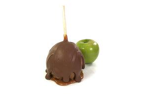 This is a caramel apple  covered in milk chocolate.  There is also a Granny Smith apple in the background.
